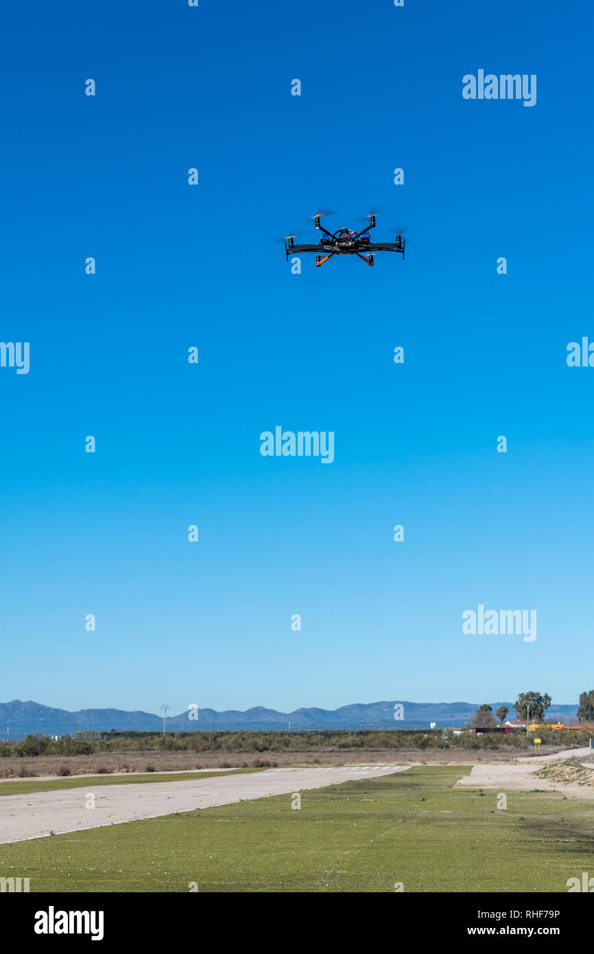 Professional drone flying over the airfield in hover Stock Photo