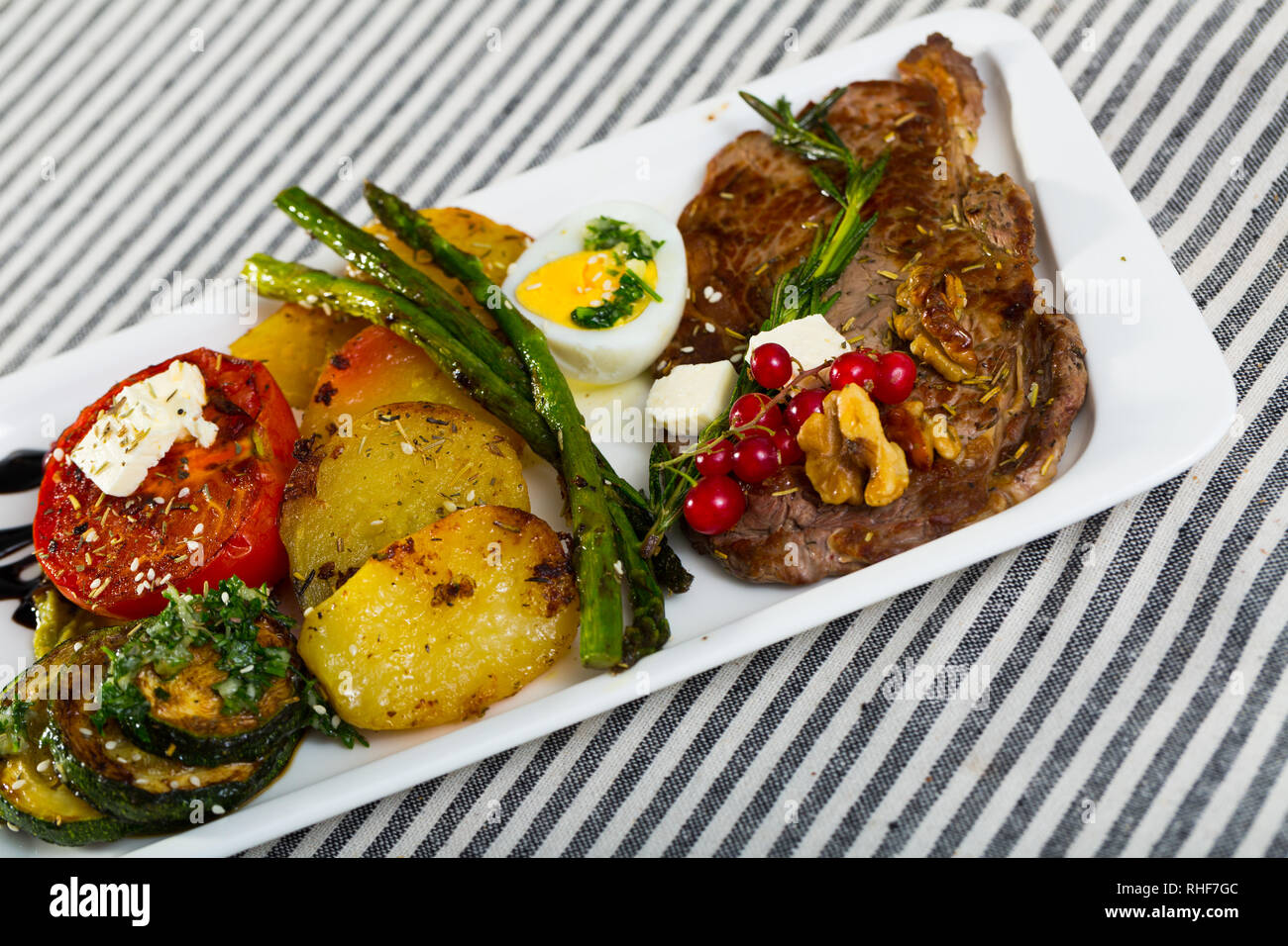 Healthy dinner veal steak baked in oven with different vegetables Stock
