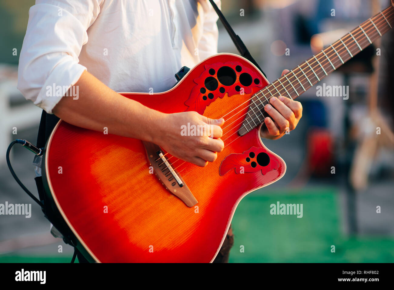 A man plays a guitar dressed in a white shirt. Stock Photo