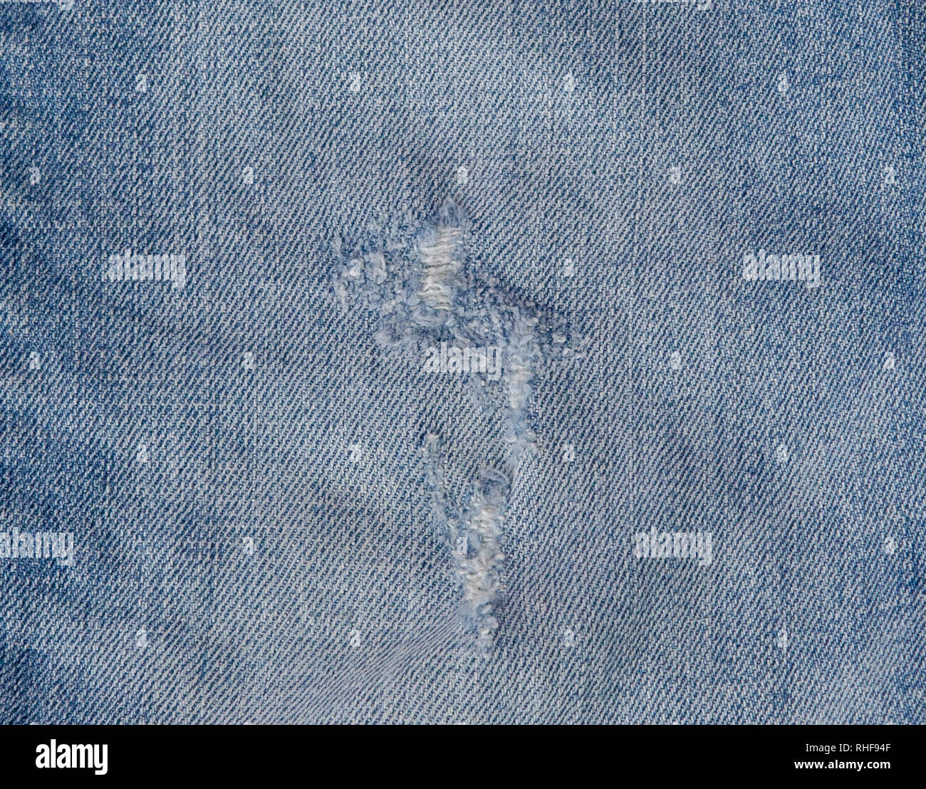 Hole and Threads on Denim Jeans. Ripped Destroyed Torn Blue jeans