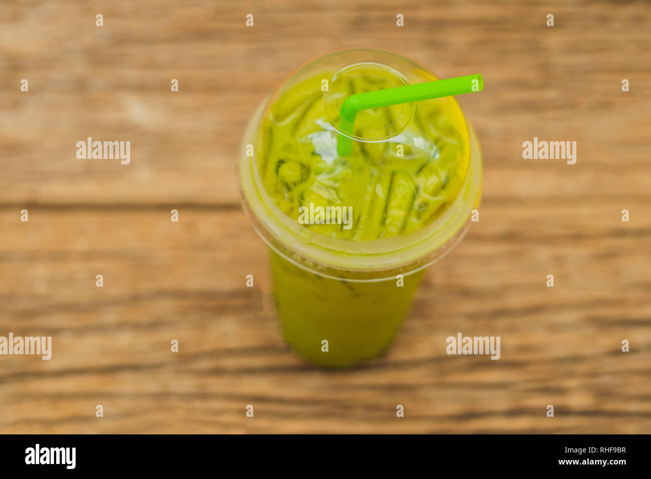 https://c8.alamy.com/comp/RHF9BR/green-tea-latte-with-ice-in-plastic-cup-and-straw-on-wooden-background-homemade-iced-matcha-latte-tea-with-milk-take-away-RHF9BR.jpg