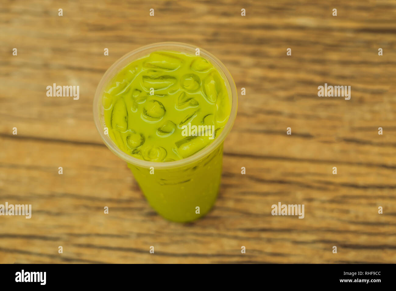 https://c8.alamy.com/comp/RHF9CC/green-tea-latte-with-ice-in-plastic-cup-and-straw-on-wooden-background-homemade-iced-matcha-latte-tea-with-milk-take-away-RHF9CC.jpg