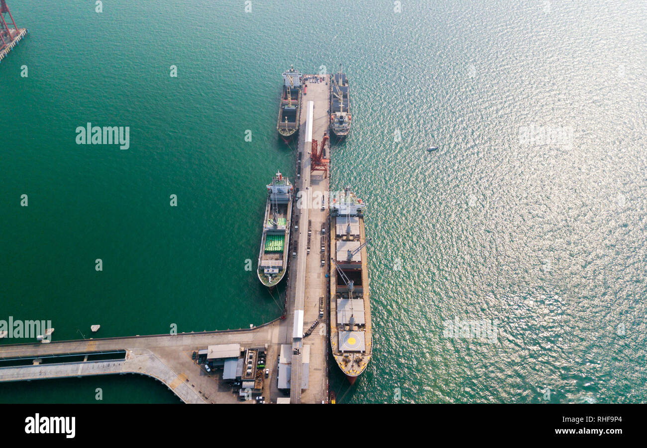 Aerial view of container ship in import - export business industry in Sriracha industrial port, Chonburi, Thailand. Stock Photo