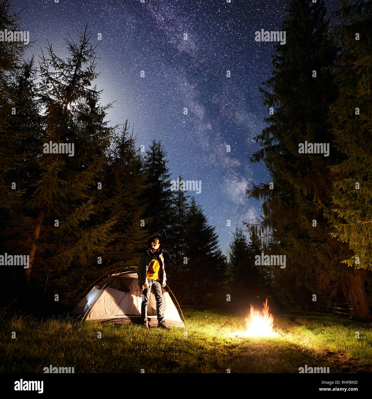 Camping Site At Night Tourist Tent On Forest Clearing And Young Hiker 