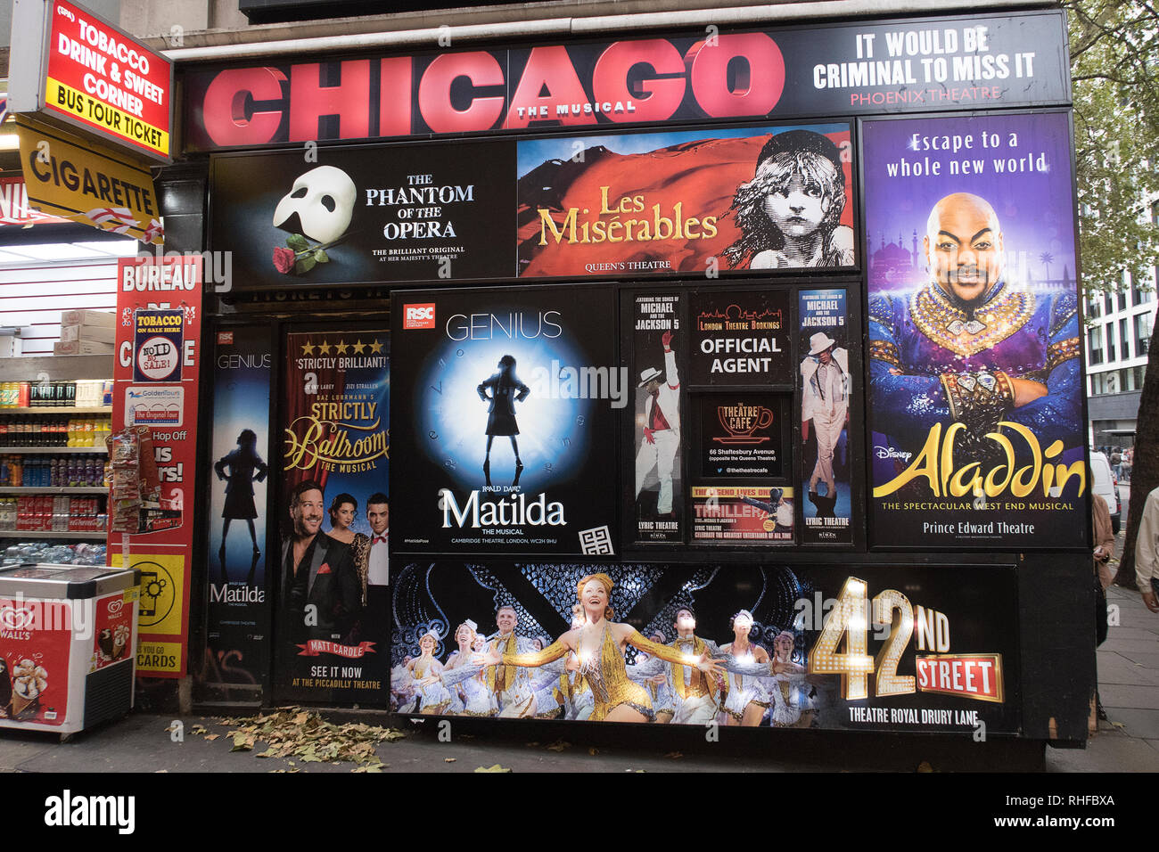 London, England - October 12, 2018: posters and flyers advertising musical shows like chicago, aladdin and Matilda on a wall in the corner of a street Stock Photo