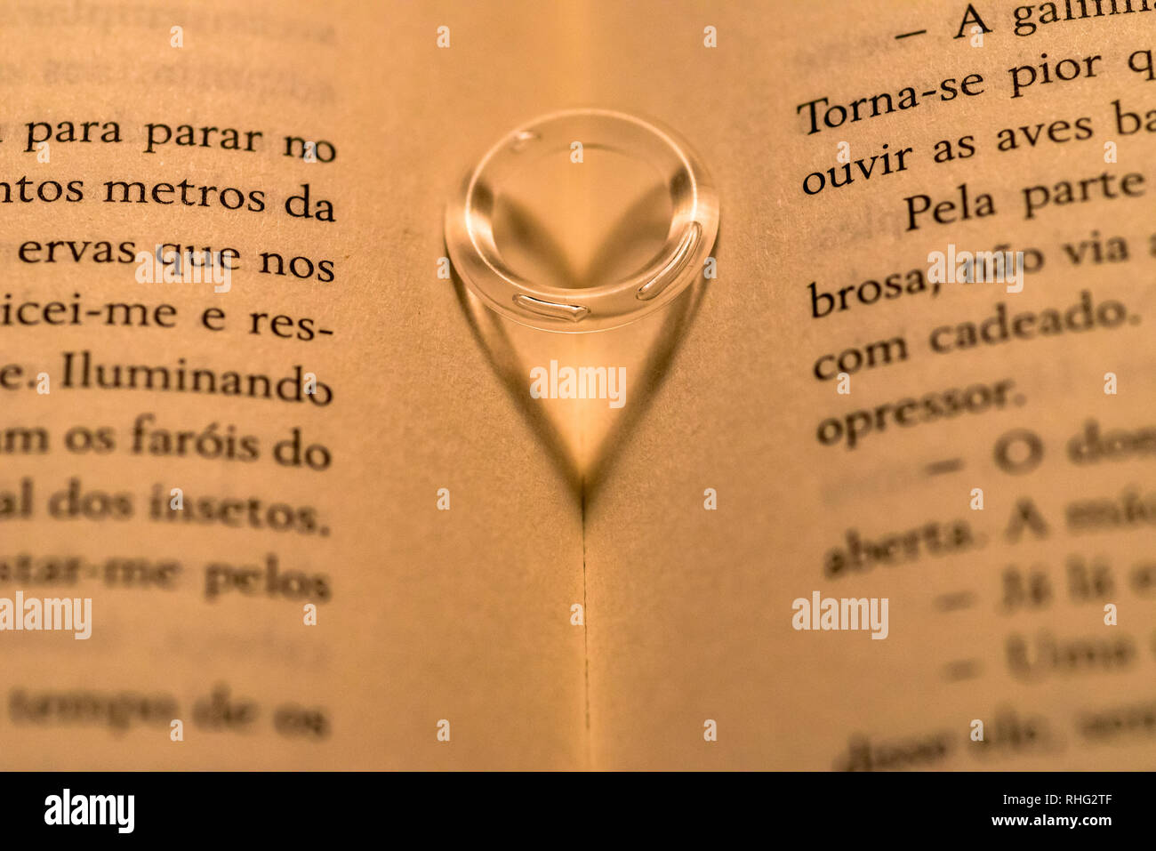 Ring over a book casting a hearth shape shadow Stock Photo