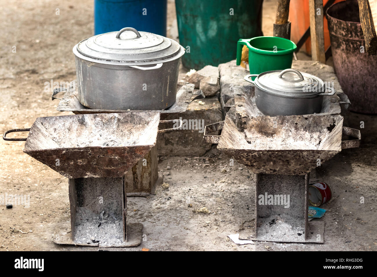 Rustic charcoal stoves and cookware, pots and pans on the floor at the local market of Toliara, Madagascar. Stock Photo