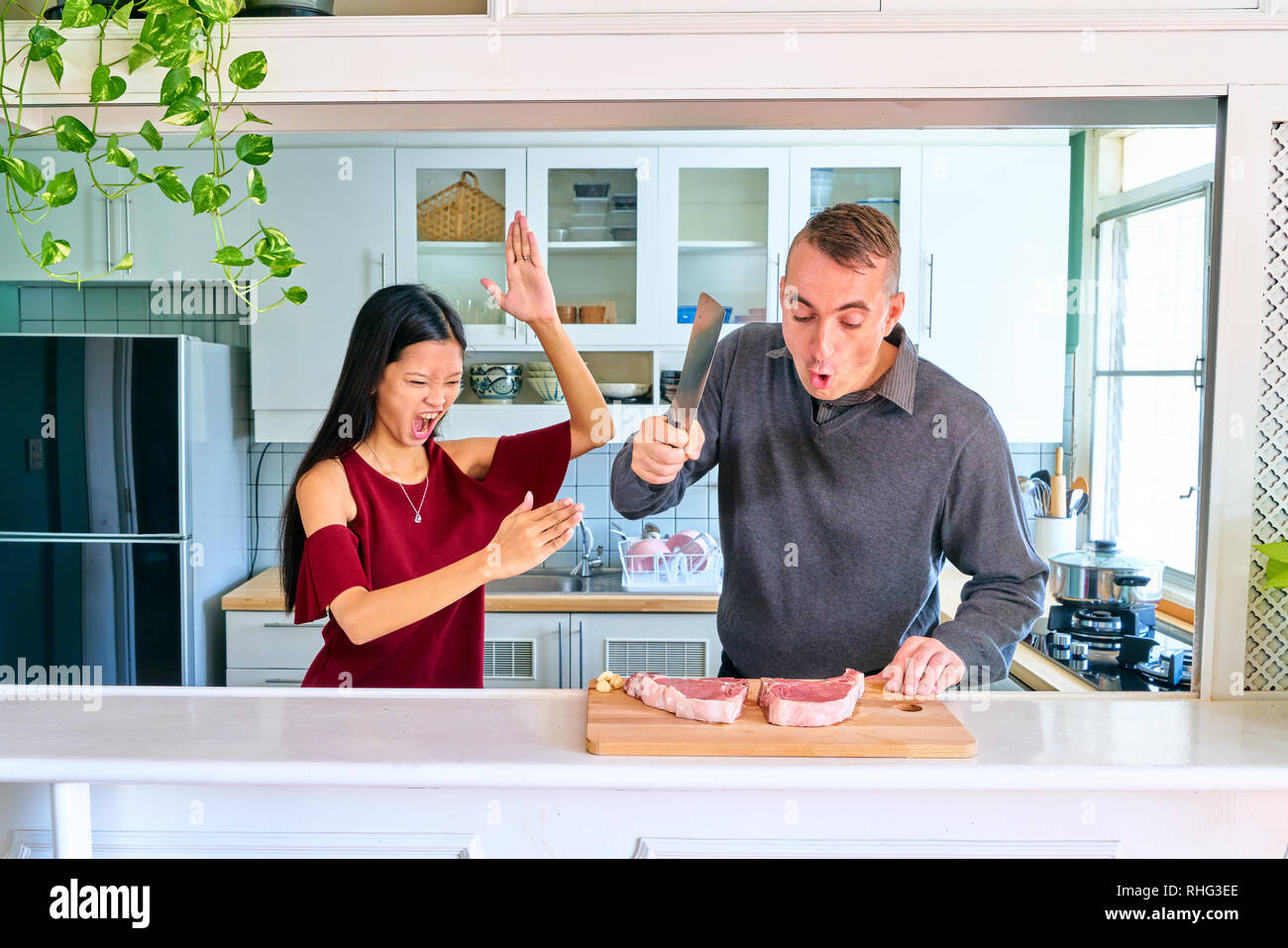 Lovely couple posing - young woman do the karate position to chop the meat and man chopping Stock Photo