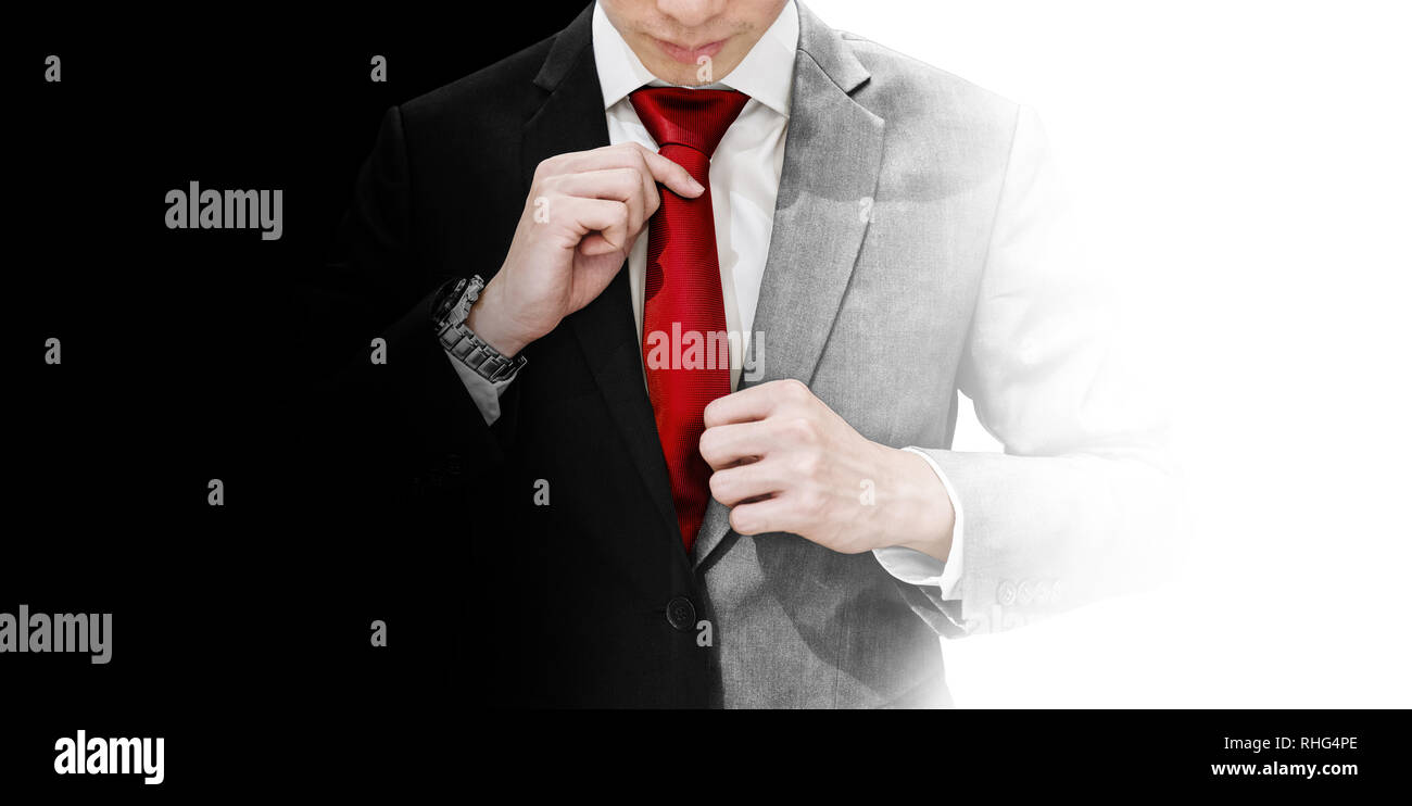 Businessman in blank and white suit tying red necktie. Good and devil, true identity, and balance concept Stock Photo