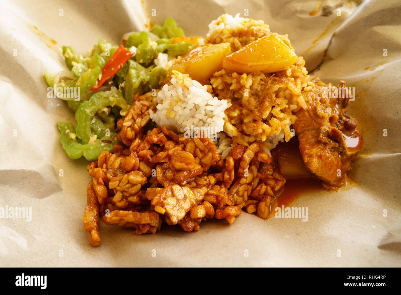 Typical Malaysian daily lunch called Nasi Campur or Nasi Bungkus which is loosely translated as rice mixed with vegetable, tempe, chicken or fish. Stock Photo