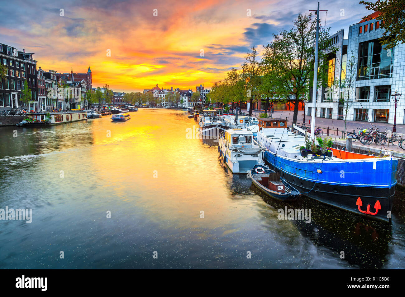 Admirable travel and touristic destination, gorgeous cityscape with traditional dutch houses. Water canal with houseboats at sunset, Amsterdam, Nether Stock Photo
