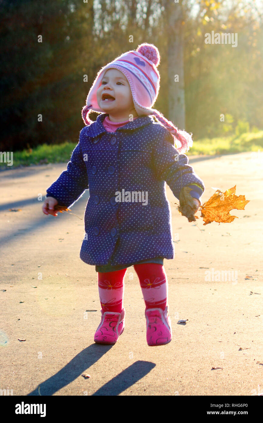 child in a red coat with autumn leaves Stock Photo - Alamy