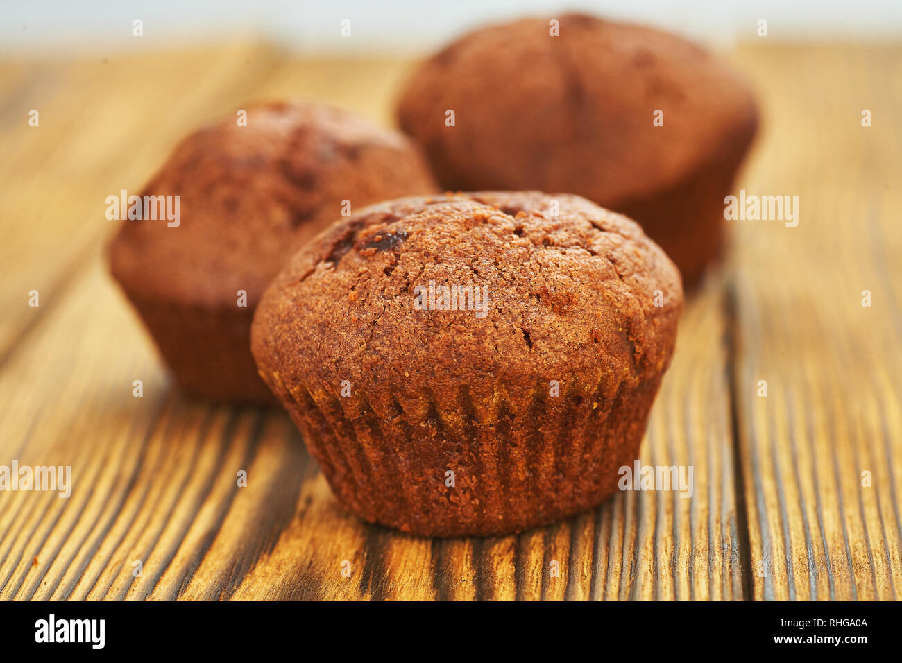 Chocolate muffin with dark background test on an old wooden table. Stock Photo