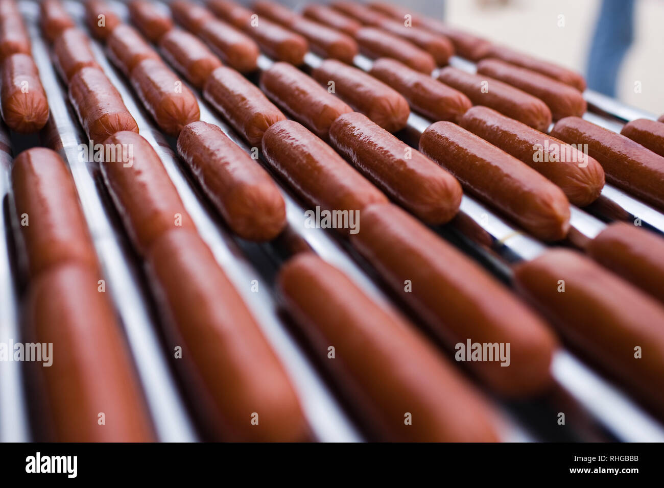 Several hot dogs cooking on a roller machine Stock Photo
