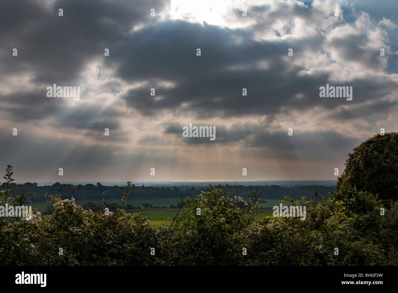 Landscape in West Sussex, UK with the sun streaming through the clouds Stock Photo