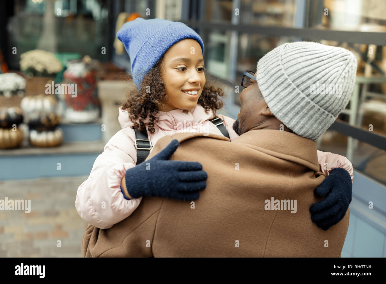 Beautiful curly daughter feeling happy seeing her father after school Stock Photo