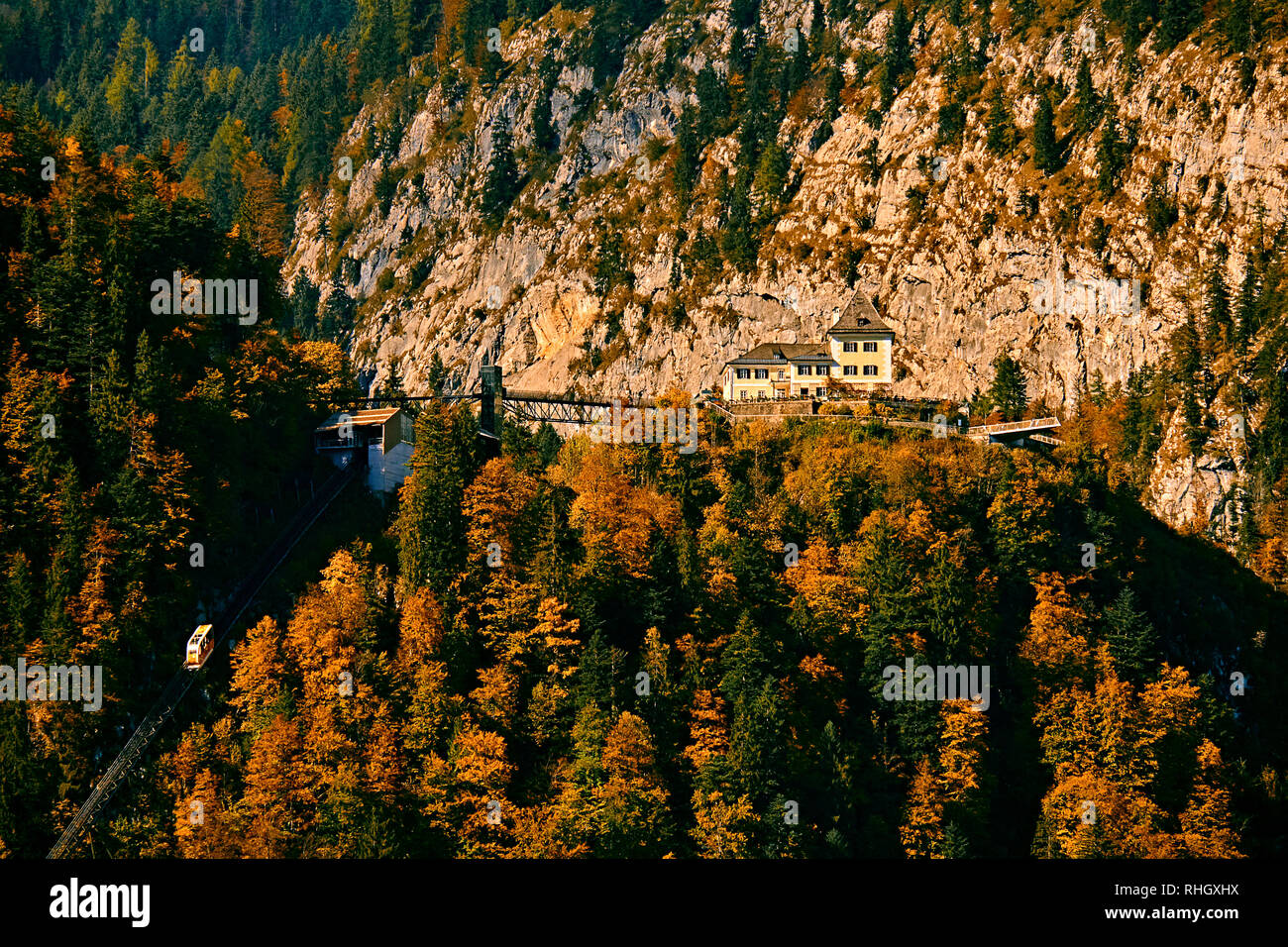 Beautiful aerial fall view of cable car ropeway funicular in austrian alps. Red cable railway car in the mountains by resort village Hallstatt, Salzka Stock Photo