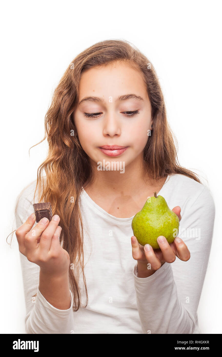 Young girl choosing between fruit and chocolate isolated on white background Stock Photo
