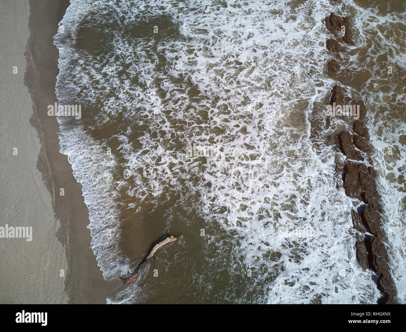 Wave on beach above top view from drone on sunny day Stock Photo