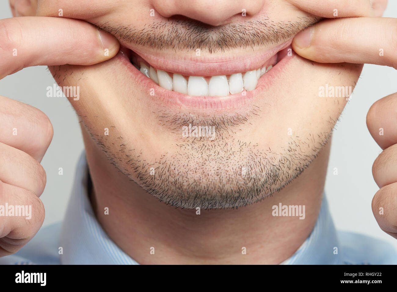 Training to make smile with teeth helping with fingers Stock Photo