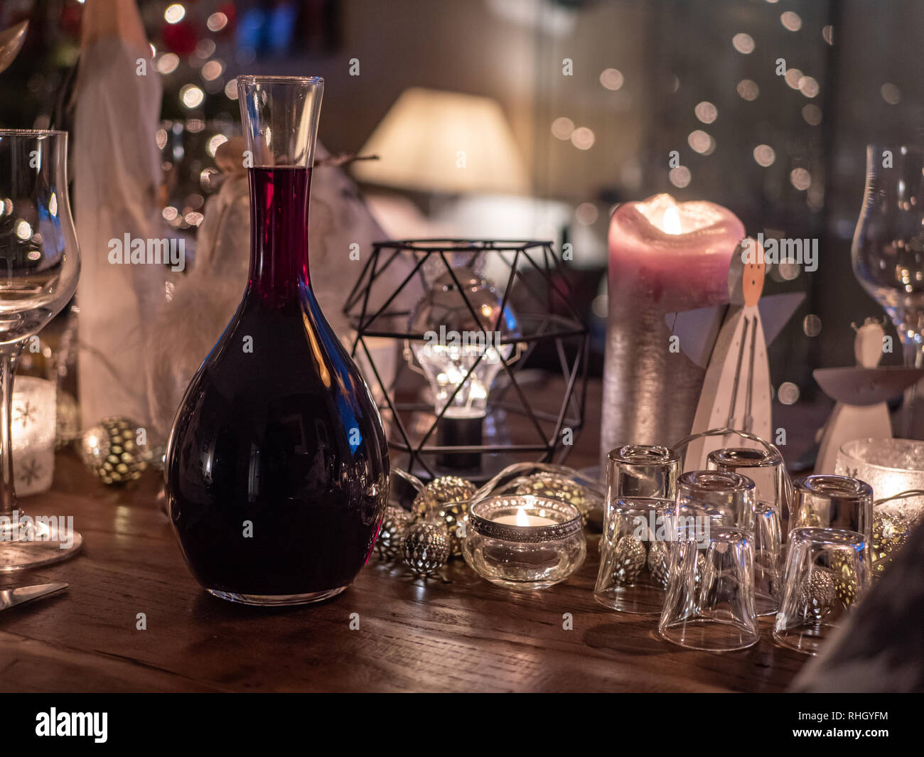 Detail of table decorated for Christmas with carafe of red wine. Shallow depth of field with wine and glasses in focus. Stock Photo