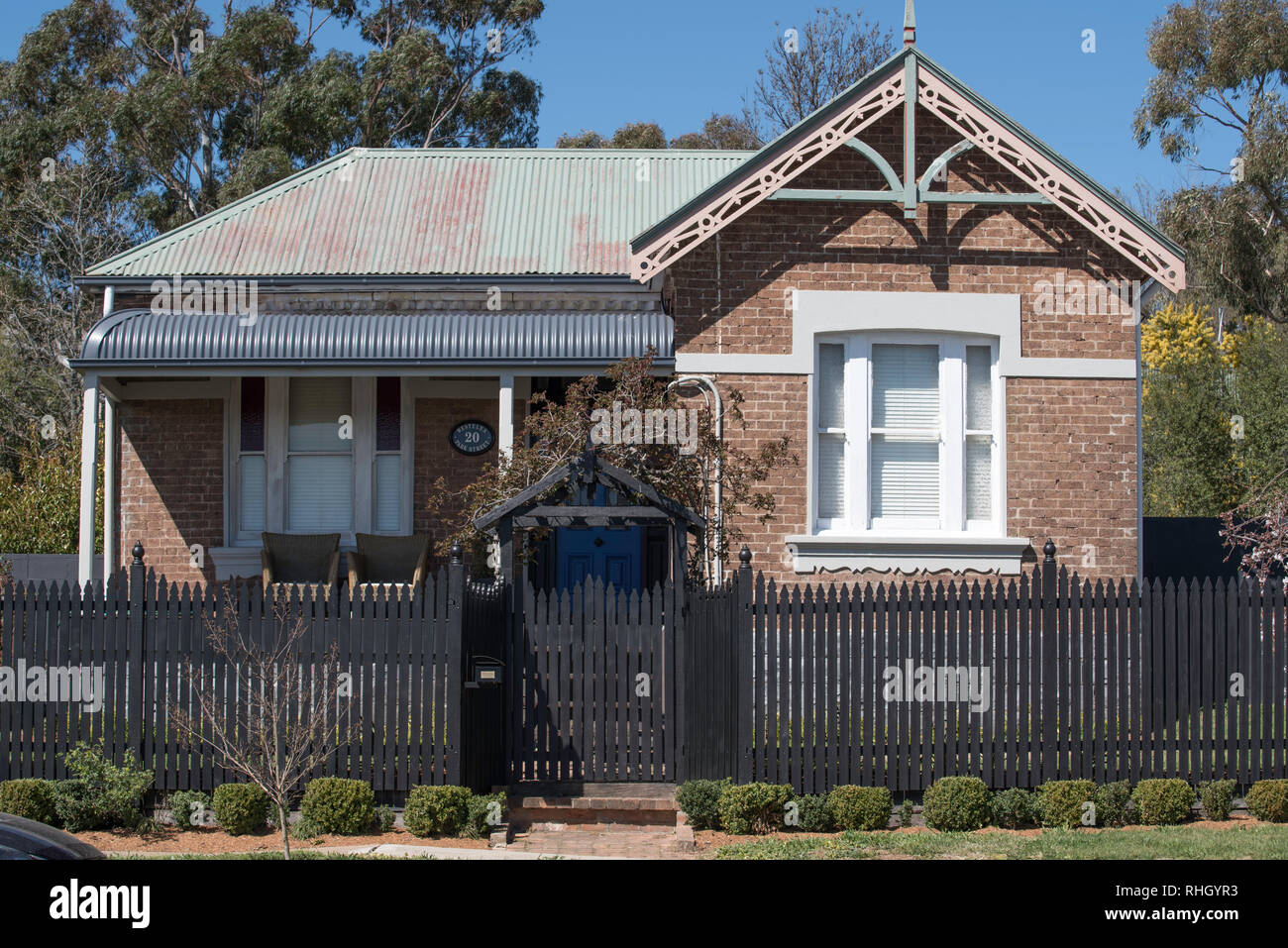 A Federation era brick and steel roofed home with a bull nose front veranda and fret work over the hip roof end in Millthorpe, New South Wales, Aust. Stock Photo