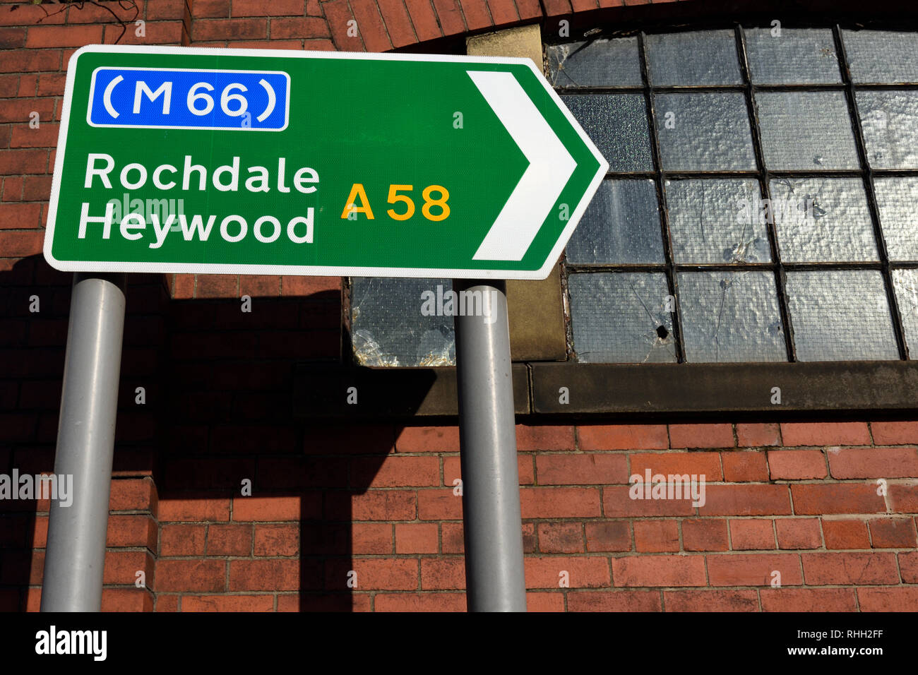 Road sign m66 rochdale heywood a58 with old window behind in bury