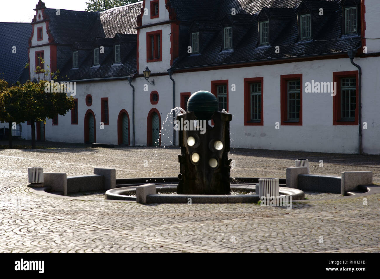 The forecourt of Hadamar Castle with a fountain in front of the Glass Museum. Stock Photo
