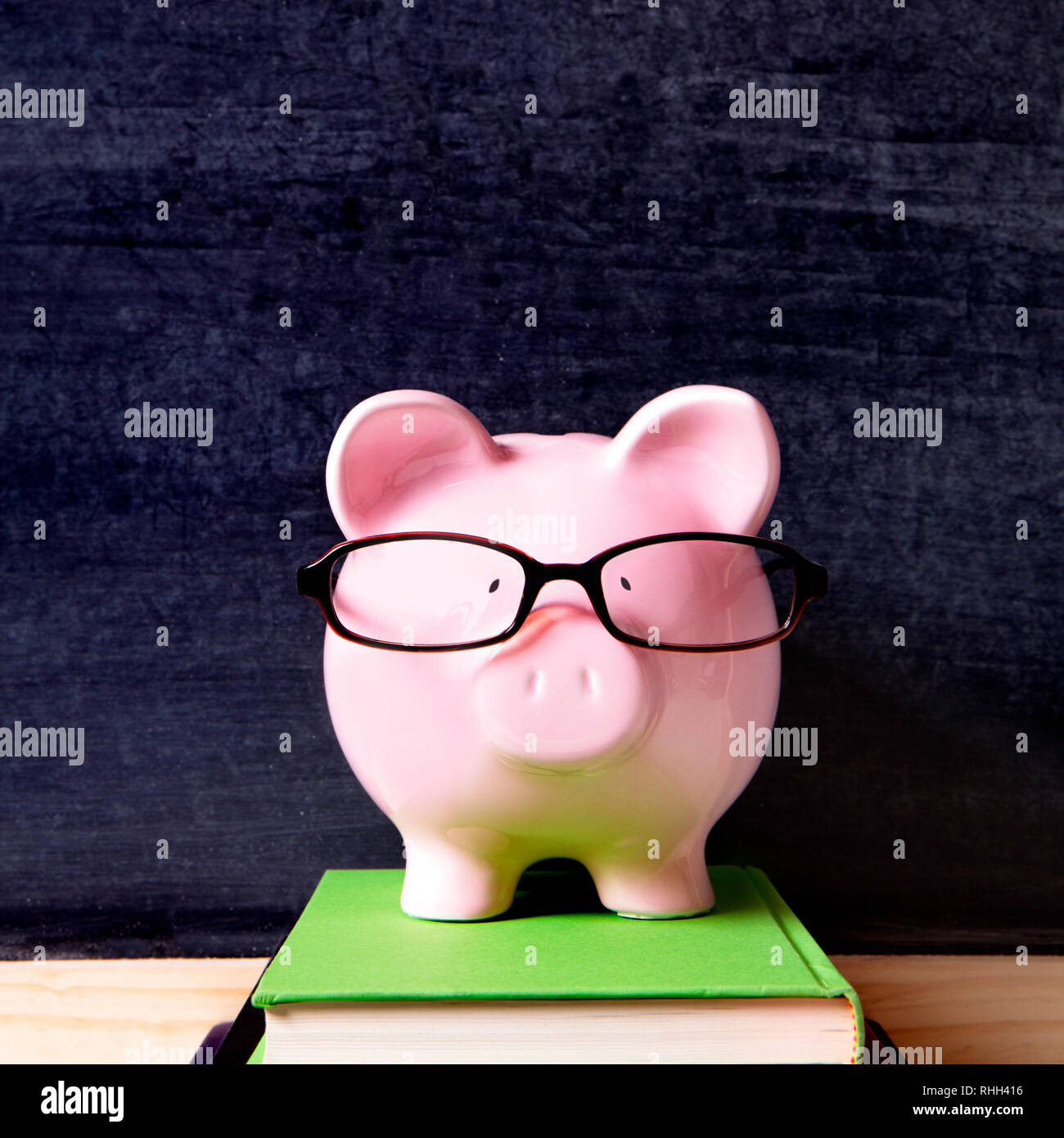 Piggy bank with glasses and blackboard Stock Photo - Alamy