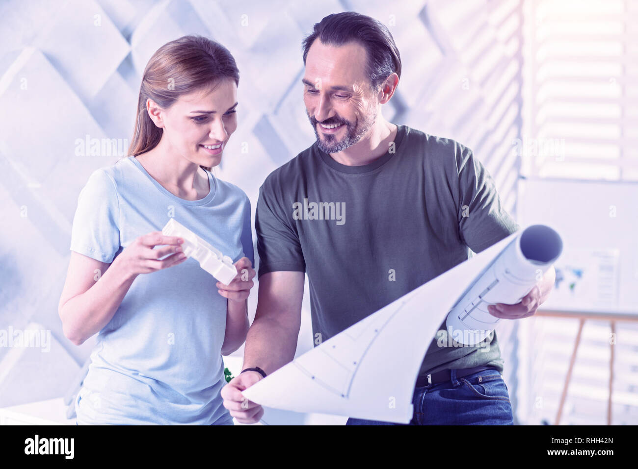 Friendly architects smiling while looking at the new blueprint Stock ...