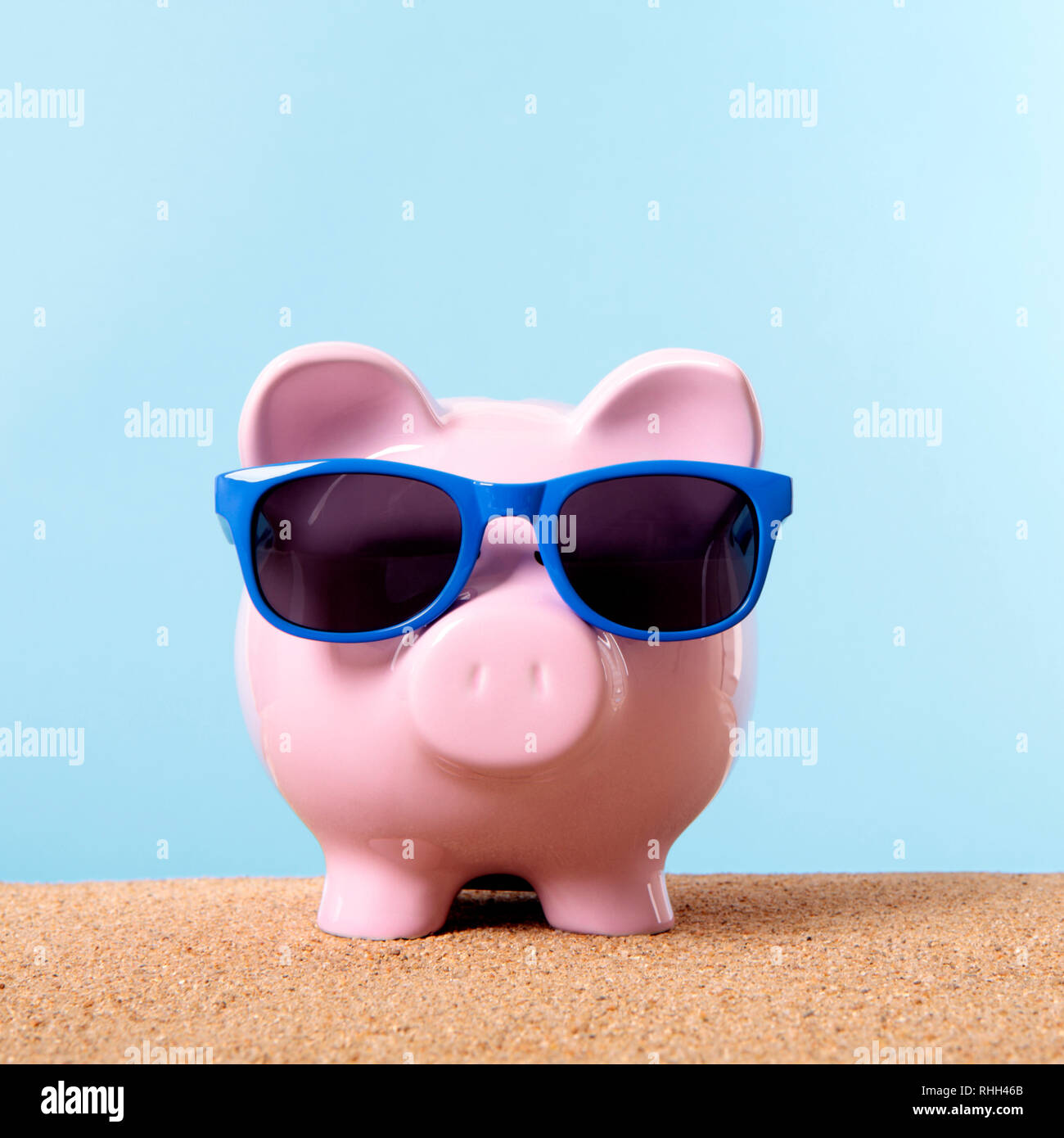 Pink piggy bank beach travel vacation savings sunglasses. Stock Photo