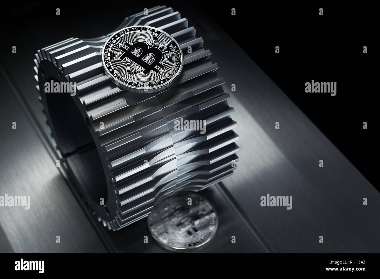 Silver bitcoin lies on the metal gearwheel. Digital Crypto currency ...