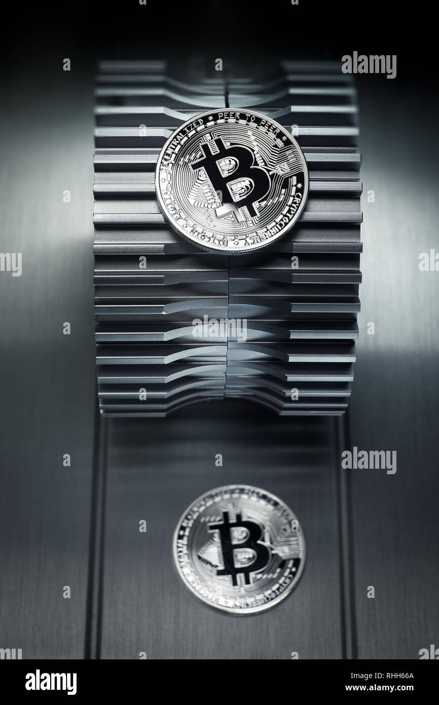 Silver bitcoin lies on the metal gearwheel. Digital Crypto currency revolution. Stock Photo