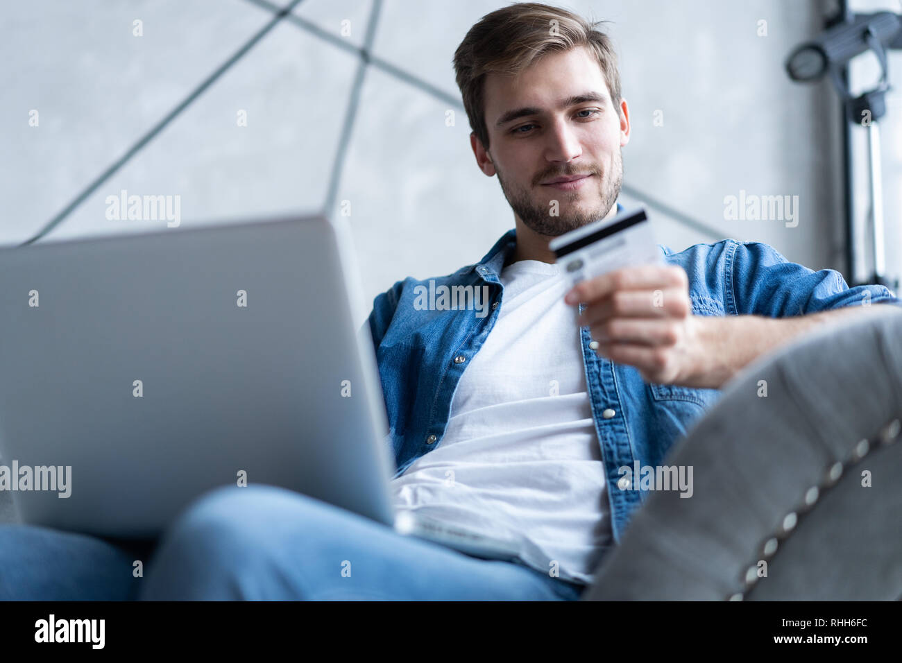 technology, shopping, banking, home and lifestyle concept - close up of man with laptop computer and credit card at home. Stock Photo