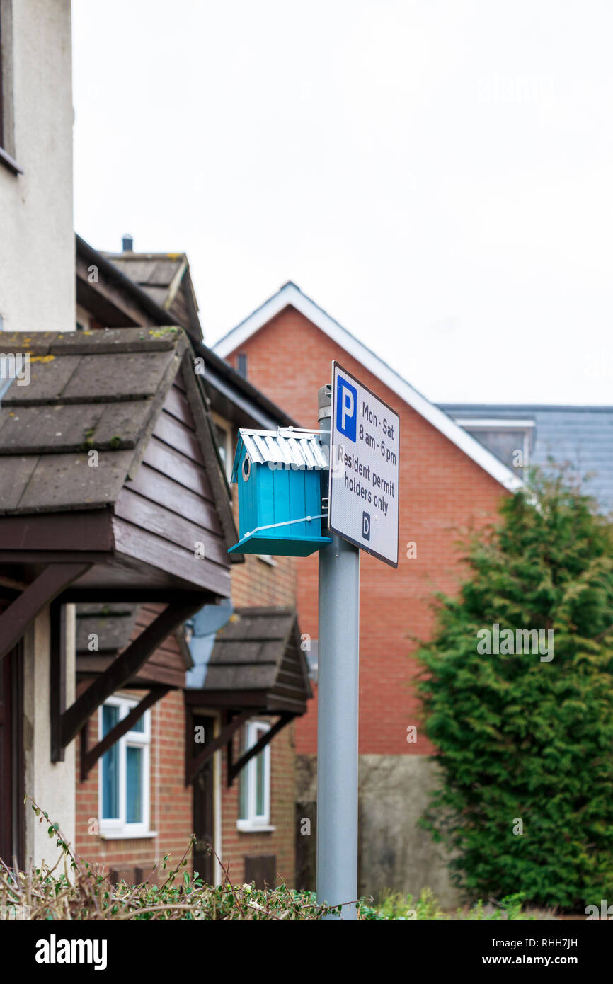 Bird nesting box attached to a parking restriction sign at the front of a house Stock Photo