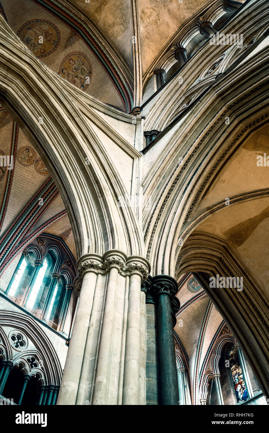 Looking up at a section of ceiling and ornate stone carved pillars and arches in Salisbury Cathedral Stock Photo