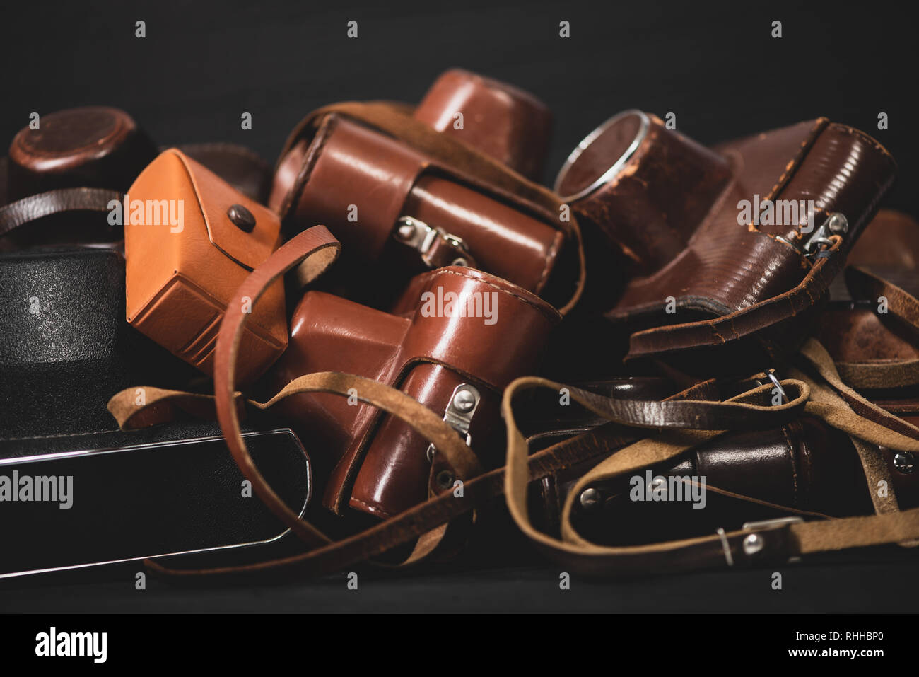 Heap of 35mm vintage cameras in leather covers. Collecting Stock Photo