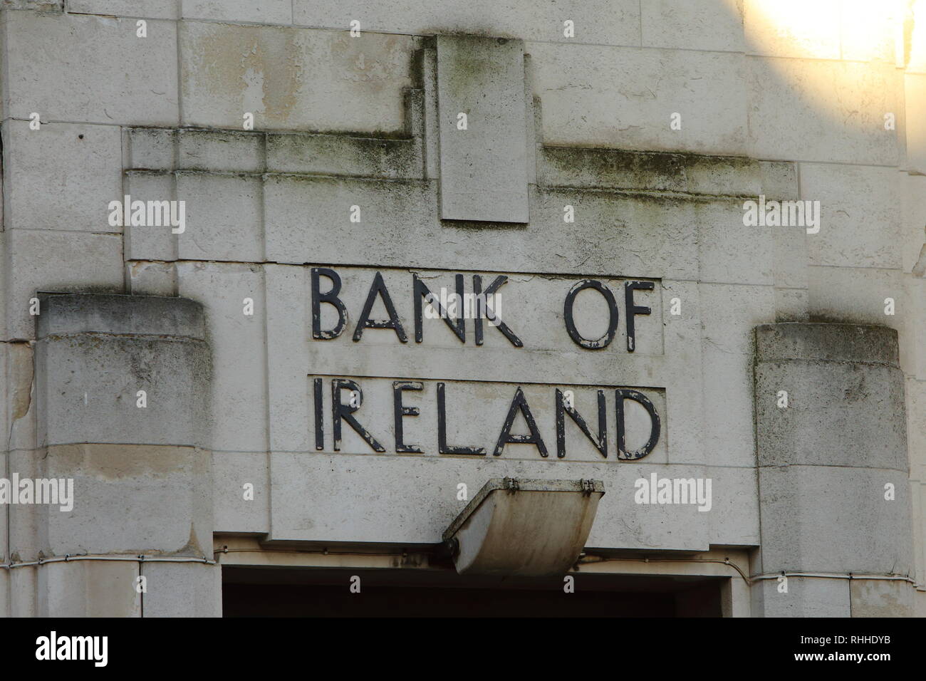 Old Bank of Ireland type font as seen on a building in Belfast, County Antrim. Standing on the corner of Royal Parade and North Street in the centre of Belfast (less than half a mile north of Donegall Square and the City Hall) the former Bank of Ireland Building is one of the finest Modernist buildings in Ireland. The building was constructed during 1929 and 1930 to designs by Joseph Vincent Downes. Born in 1891, Downes studied architecture at University College Dublin before graduating in 1920. During his studies Downes worked an apprenticeship at the architectural practice of Lucius O'Callag Stock Photo