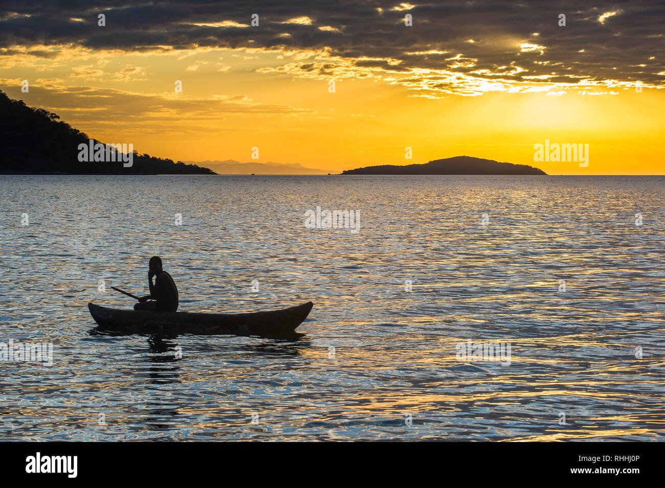 Man in a little fishing boat at sunset, Lake Malawi, Cape Maclear, Malawi Stock Photo