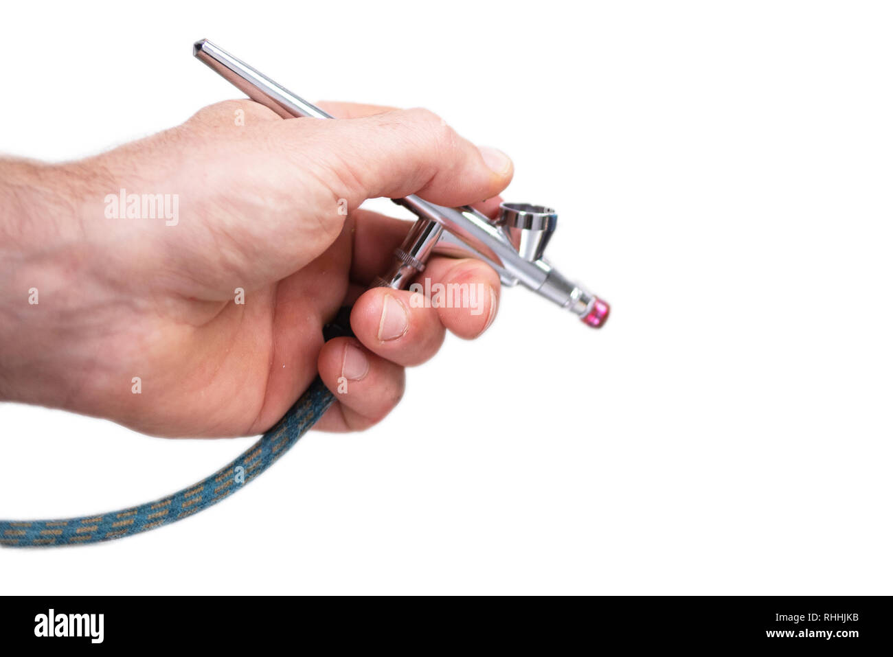 Hand holding airbrush tool on white isolated background . Stock Photo