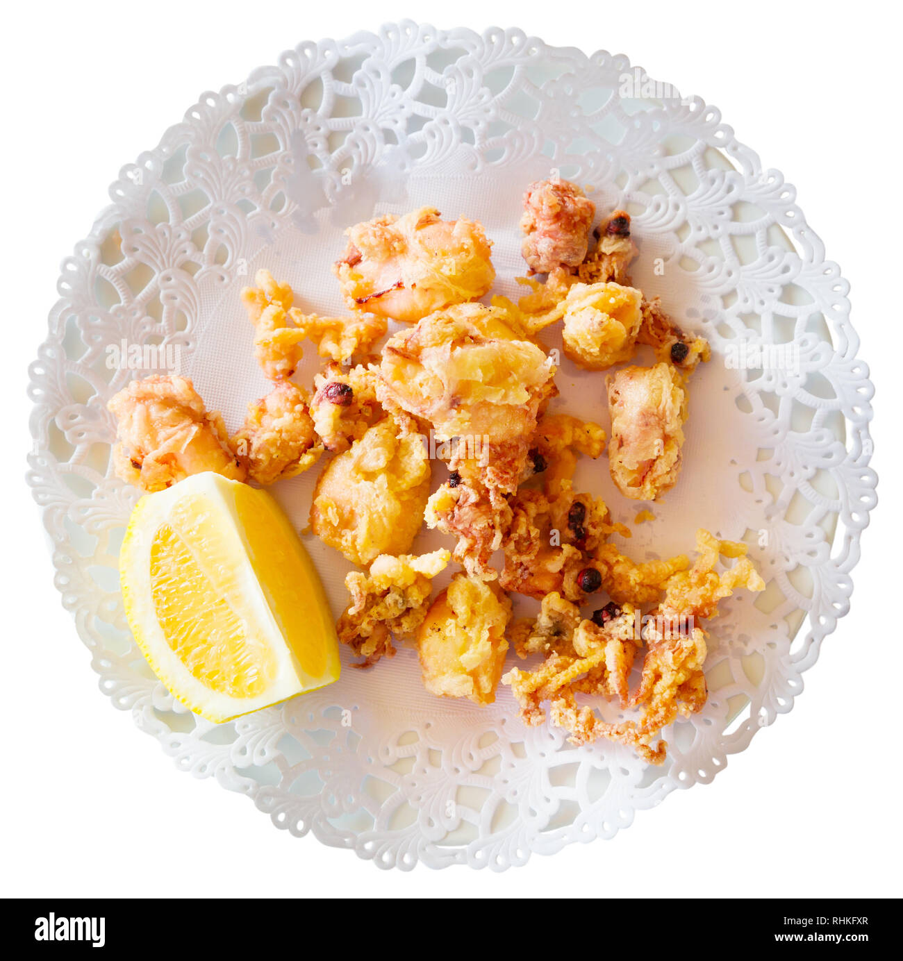 Chipirones, battered fried baby squid served with lemon on white plate