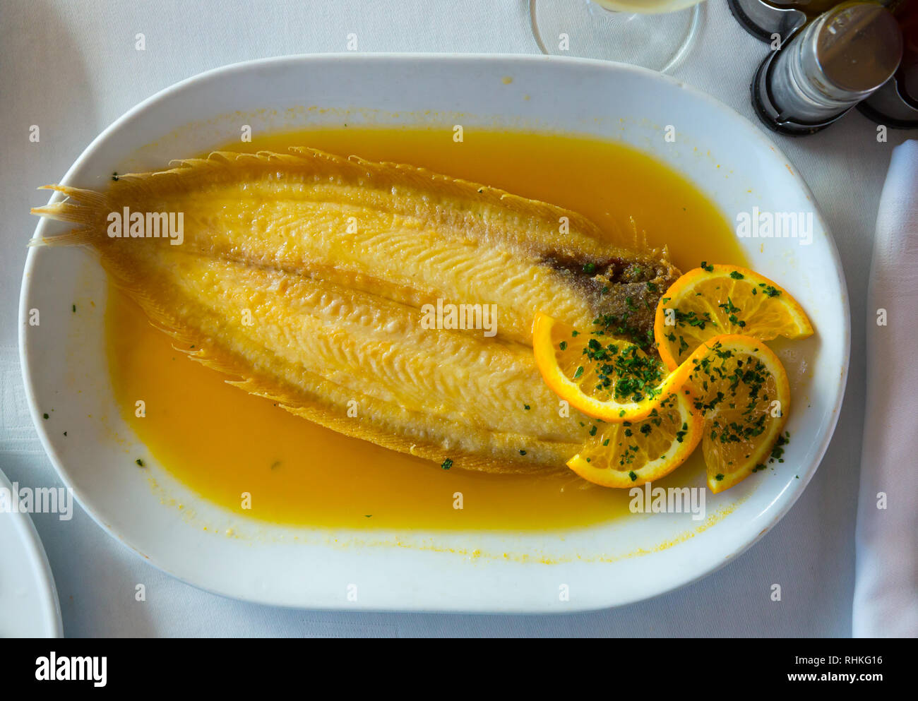 Delicious dover sole cooked in orange sauce served on white plate Stock Photo