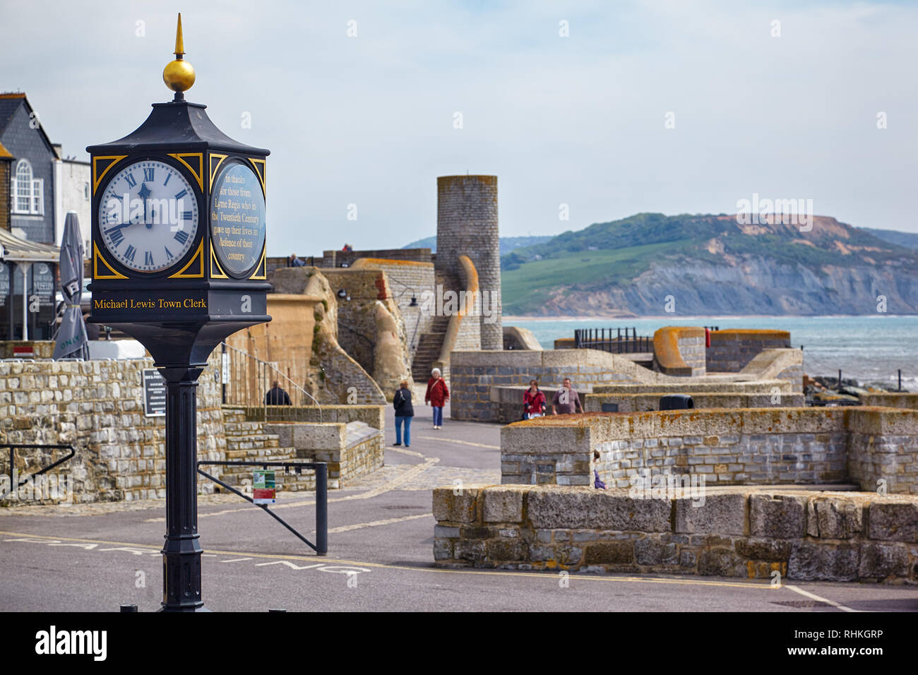 LYME REGIS, ENGLAND - MAY 12, 2009: Lyme Regis 20th century conflicts clock in the Cobb Gate Car Park and the Gun Cliff on the background. Lyme Regis. Stock Photo