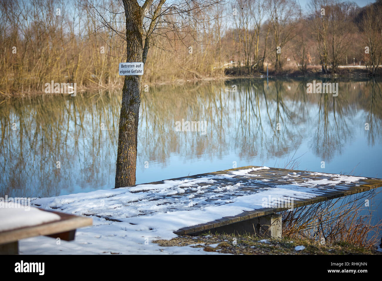 lake with warning Betreten auf eigene Gefahr Stock Photo