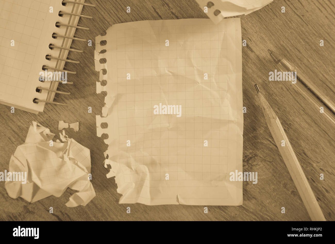 Empty crumpled pages and notebook lying on wooden surface Stock Photo
