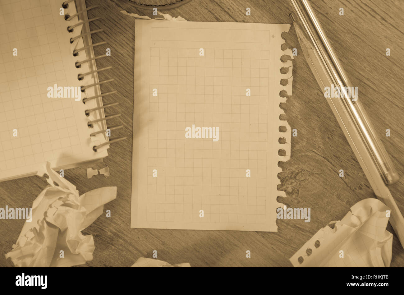 Empty crumpled pages and notebook lying on wooden surface Stock Photo