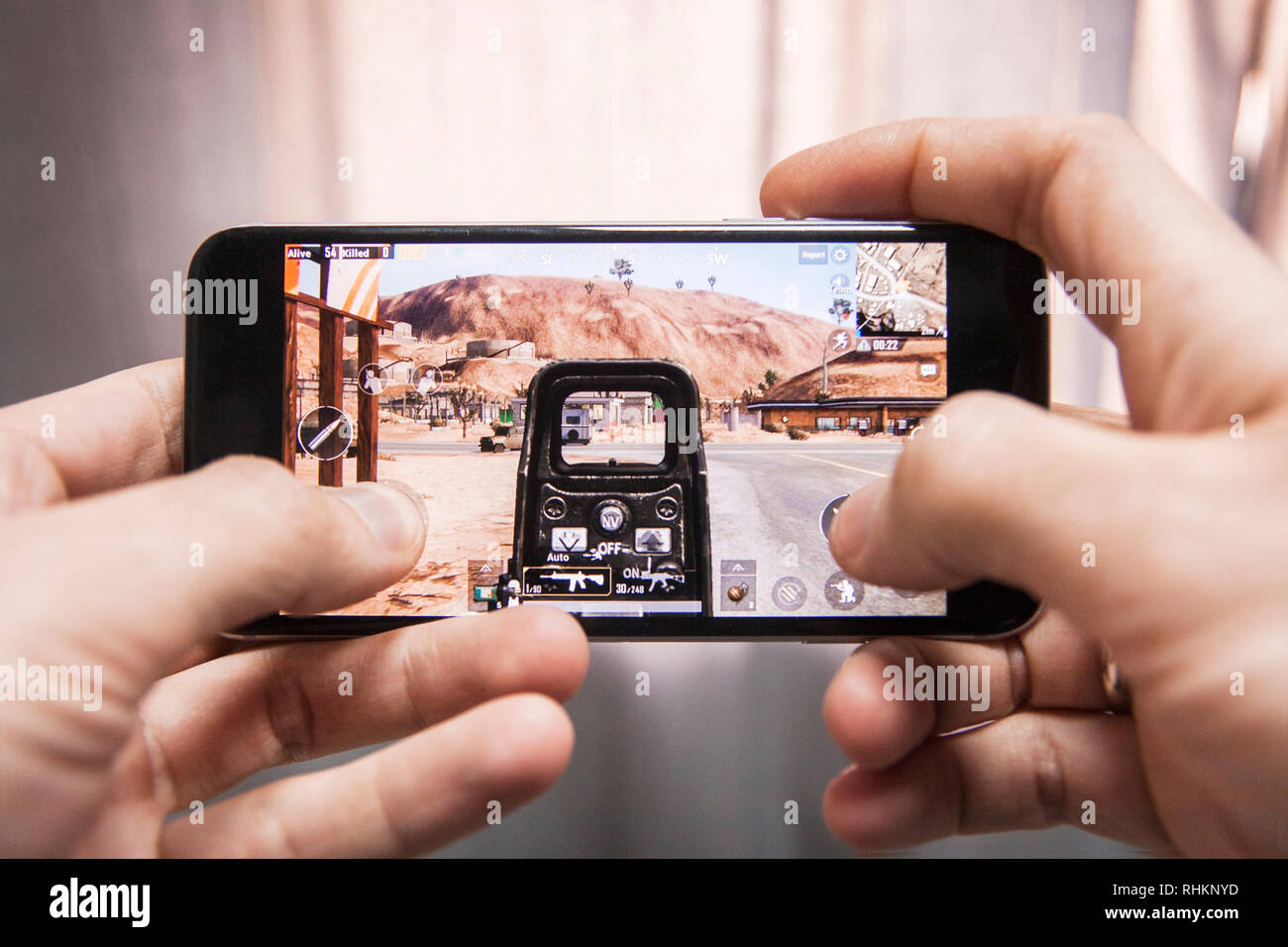 Los Angeles, California, USA - 17 December 2018: Hands holding a smartphone with Player's Unknown Battleground also known as PUBG online shooting FPS  Stock Photo
