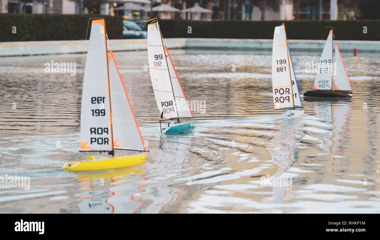 Small sailing toy boats race. Mini remote controlled pond sail boats