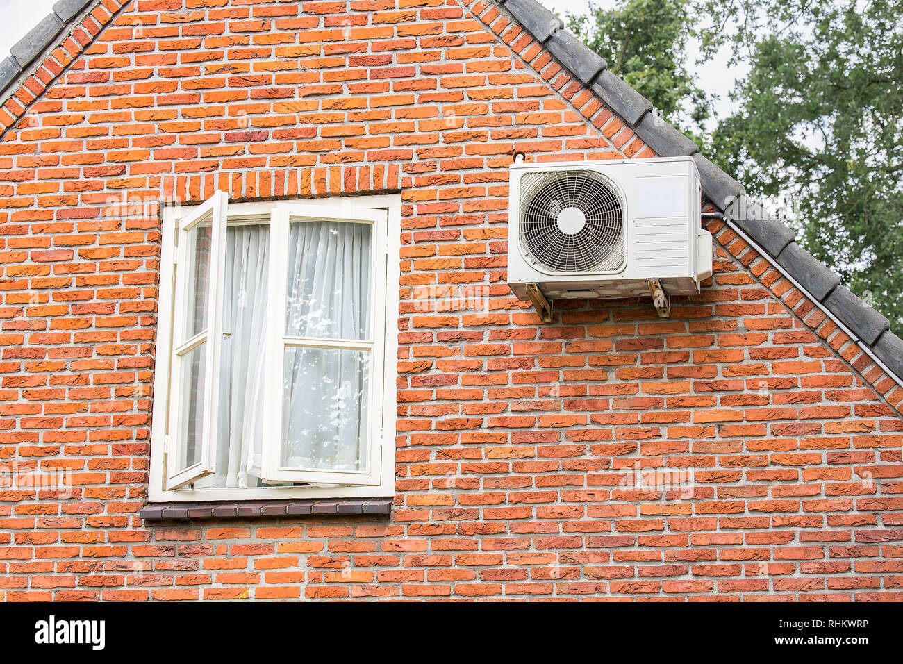 Brick wall of home with window and air conditioner Stock Photo