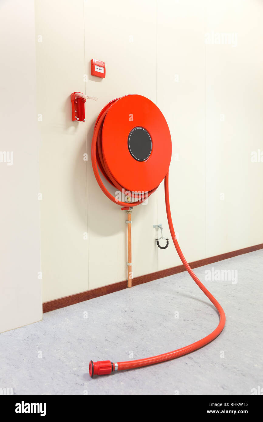 Red fire hose in building to fight a fire Stock Photo